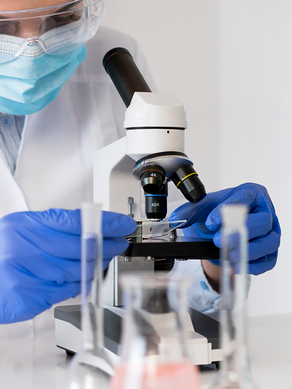 Lab specialist examining plasma under a microscope for the Microclot Test.
